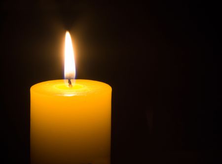 a burning candle on a black backgroundの写真素材