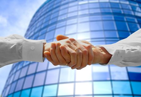 Handshake with modern skyscrapers as backgroundの写真素材
