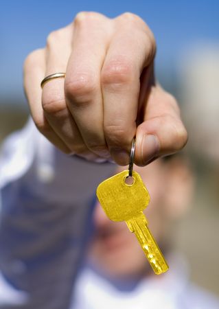 hand holds a gold key (key in focus)の写真素材