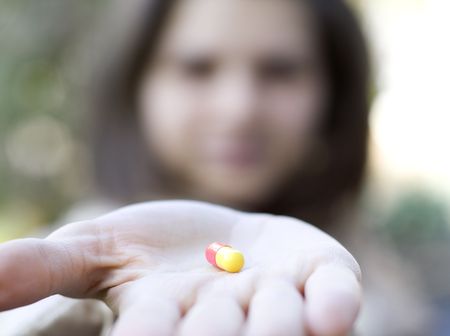 Woman holds a pill in a handの写真素材