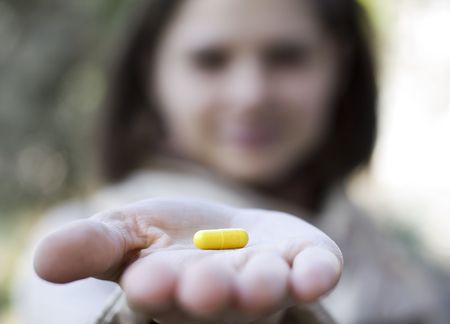 Woman holds a pill in a handの写真素材