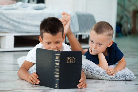 children read a bible on the bedの写真素材