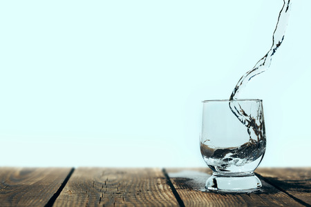 splash of water in a glass on woodの写真素材