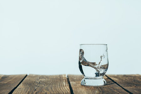 splash of water in a glass on wood