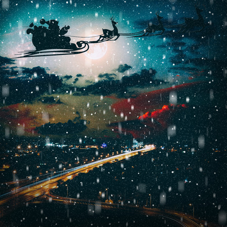 silhouette of a flying goth santa claus against the background of the night sky.