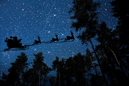 silhouette of a flying goth santa claus against the background of the night sky.の写真素材