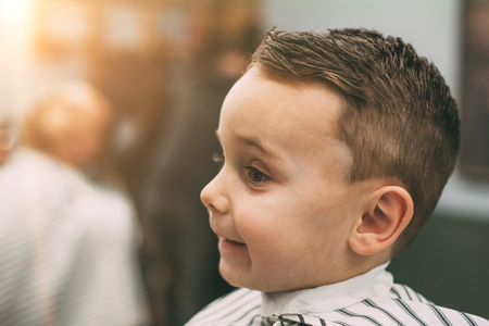 The child is being cut hairstyles in the hairdressing salonの写真素材