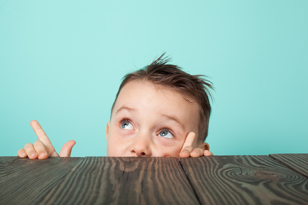 the child crawls out from under the table and looks upの写真素材