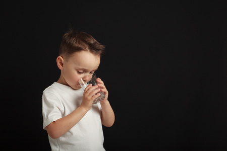 a child drinks water on a black background
