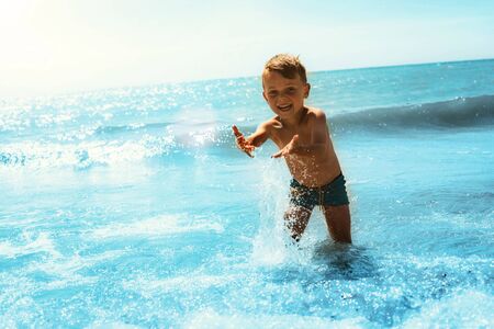 Kid running on the seashore with wavesの写真素材