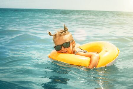 Child floats on an inflatable circle at seaの写真素材