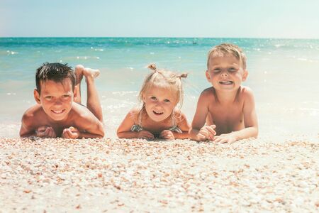Children lie on the beach of the seaの写真素材