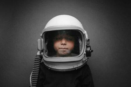 Small child wants to fly an airplane wearing an airplane helmetの写真素材