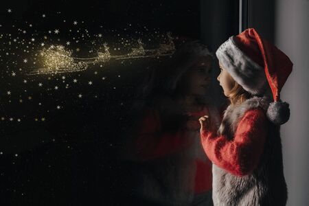 the child looks out the window on christmas of Jesus Christ.の写真素材