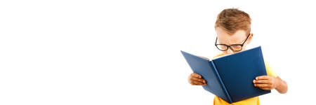 child reads a book against a bright wall