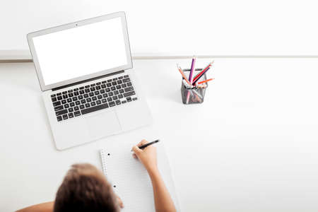 school at home through online homeschooling. the child is sitting at the computerの写真素材