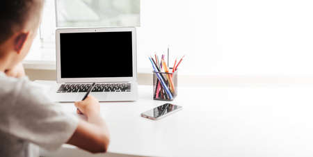 school at home through online homeschooling. the child is sitting at the computer