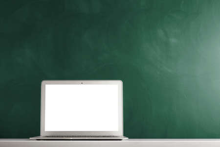 modern laptop computer on the tabl on the blackboard backgroundの写真素材