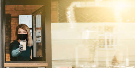 Masked barista spills coffee through the window because of coronavirus