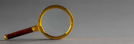 a golden magnifier on black paper background