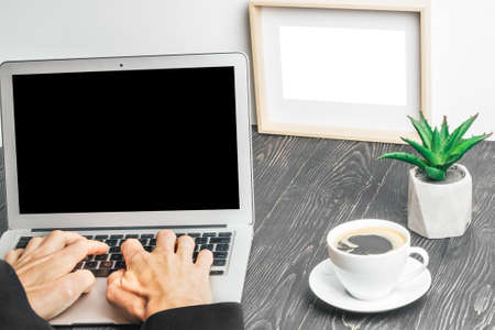 people sits on a work with a laptop computer for a wood table on the blackboard background