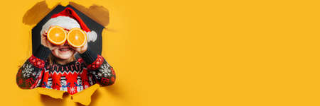 child looking at christmas present through orange on black backgroundの写真素材