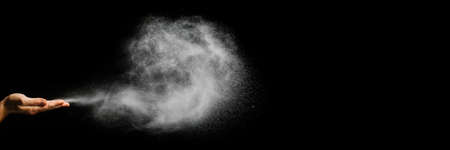snow blows from hands on black background