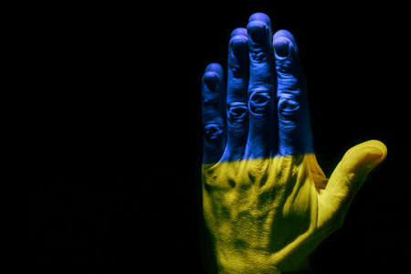 man's praying hands in the dark on Ukraineの写真素材
