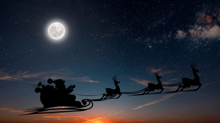 Santa Claus flies on Christmas Eve in the night sky with snowの写真素材