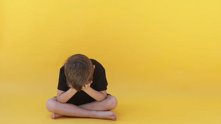 child whose depression is sitting on the color floorの写真素材