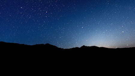 a movement of stars in the night sky with the view of mountains. . High quality photoの写真素材