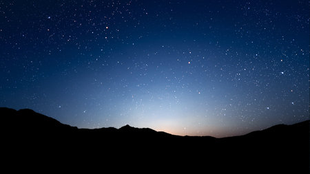 a movement of stars in the night sky with the view of mountains. . High quality photoの写真素材
