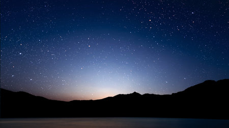 a movement of stars in the night sky with the view of mountains. . High quality photoの写真素材