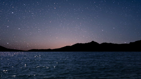 a movement of stars in the night sky with the view of mountains. . High quality photoの写真素材