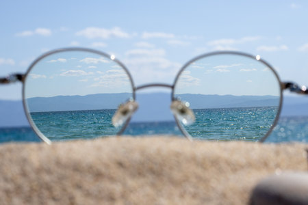 Clear sea view through glasses on a sunny beach.