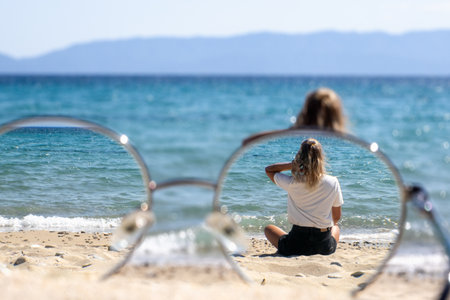 Woman relaxing alone by the sea, summer calm mood