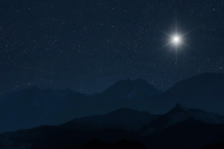 Star shines at night over the mountains.