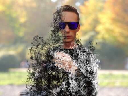 Portrait of a young man in sunglasses dissolving in smoke.