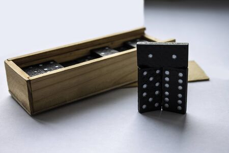 3 Dice dominoes beautifully exposed, against the background of a wooden box. Macro Light background. Black dominoes.の写真素材