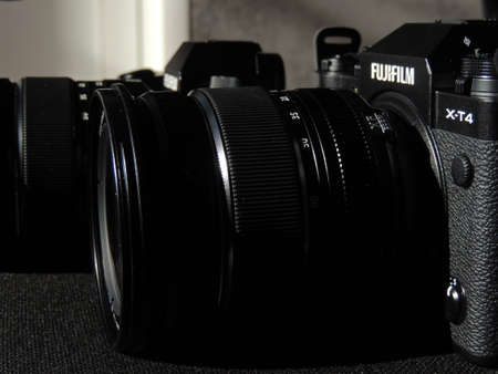 Comparison of Fujifilm X-T4 and X-S10 black cameras. The best cameras for videographers. Light background. Brand.のeditorial素材