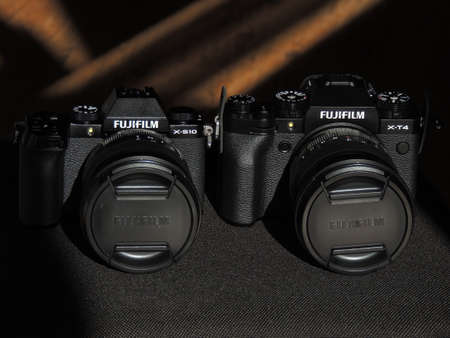 Comparison of Fujifilm X-T4 and X-S10 black cameras. The best cameras for videographers. Light background. Brand.のeditorial素材