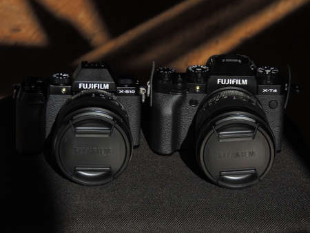 Comparison of Fujifilm X-T4 and X-S10 black cameras. The best cameras for videographers. Light background. Brand.のeditorial素材