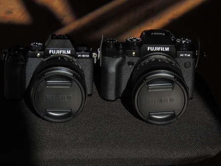 Comparison of Fujifilm X-T4 and X-S10 black cameras. The best cameras for videographers. Light background. Brand.のeditorial素材