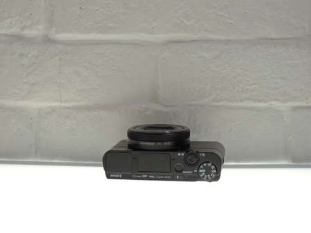 Sony Cuber-shot DSC-RX100 mark Va (rx100m5a) black, on a light white brick background.