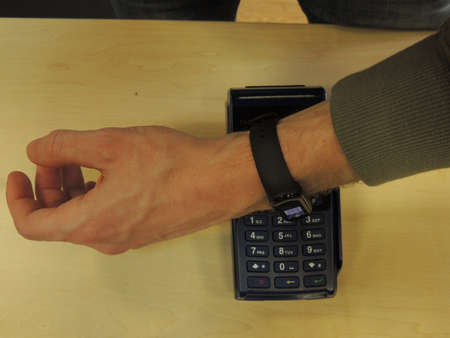 Contact less payment via the terminal for the goods, using the watch on the bracelet. NFC. Smart watch.の写真素材