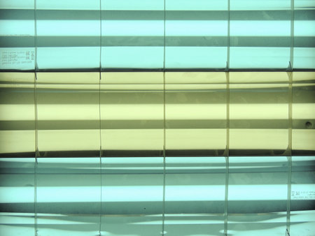 Abstract background, stripes and light from lamps. Yellow and blue colors. A chandelier made of fluorescent lamps.の写真素材