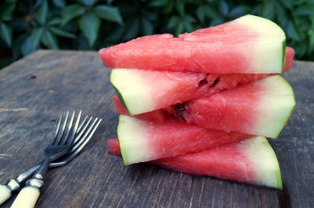 Slices of watermelon in a bowl on wooden background.の写真素材