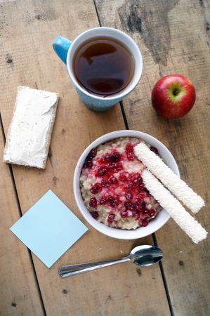 Healthy breakfast, vegetarian. Oatmeal with cranberries, apple, sandwich with cream cheese and tea, healthy eating, vegan food concept. Colorful breakfast for kidsの写真素材