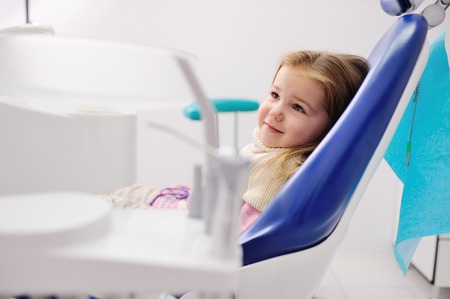cute baby girl sitting in a dental chair and looking at the camera. caries preventionの写真素材