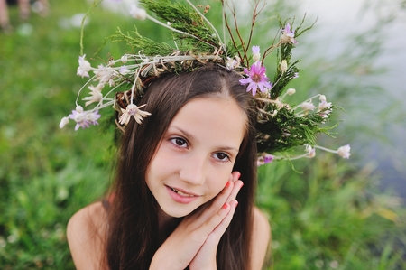 Baby girl in wreath of wild flowers and background of nature. Mid-summer day. Easter. Ivan Kupalaの写真素材